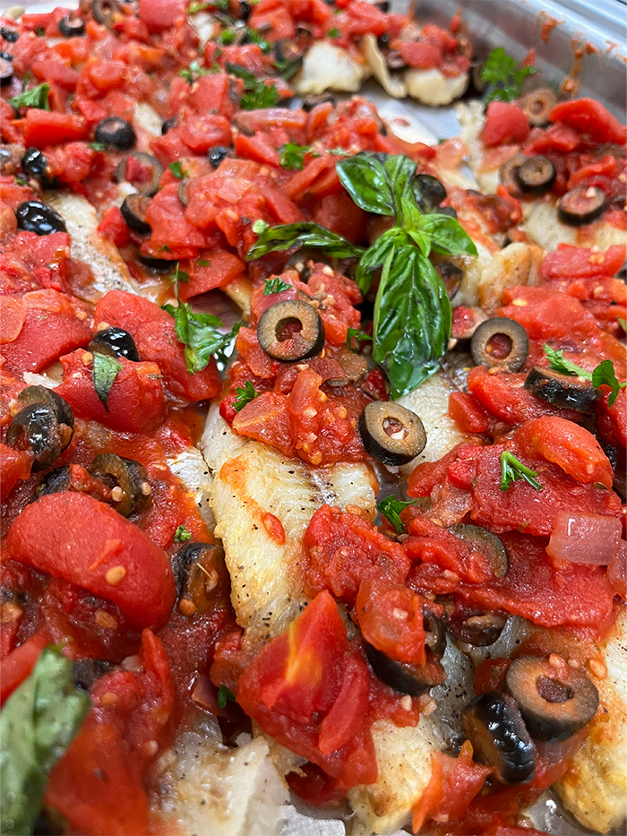 Freshly baked fish with tomato topping