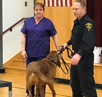 Police officer presenting to students with a dog