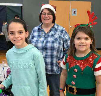 two students and a staff member dressed for Christmas