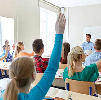 Students in class with their hands raised